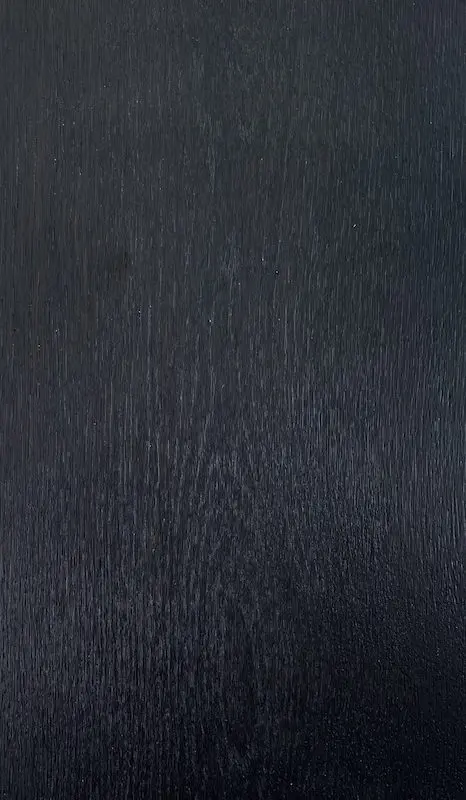 A black wood grain background with some white lines