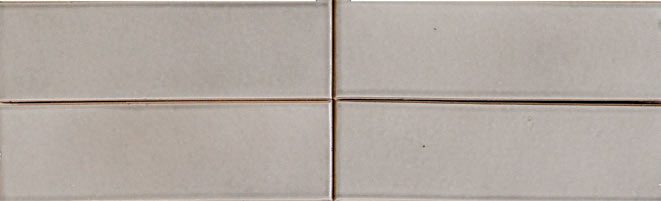 A close up of the bottom corner of a tile wall
