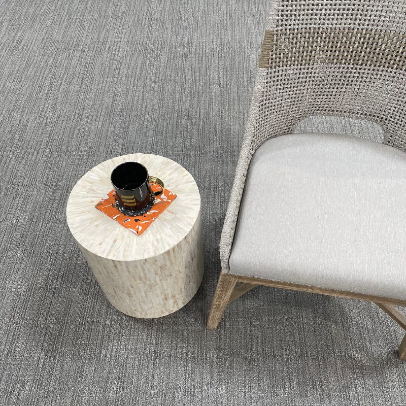 An ALTITUDE broadloom chair and a coffee table on a carpet.