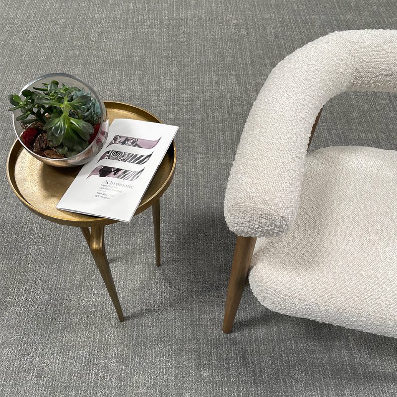 A chair next to a table with HORIZON broadloom on it.