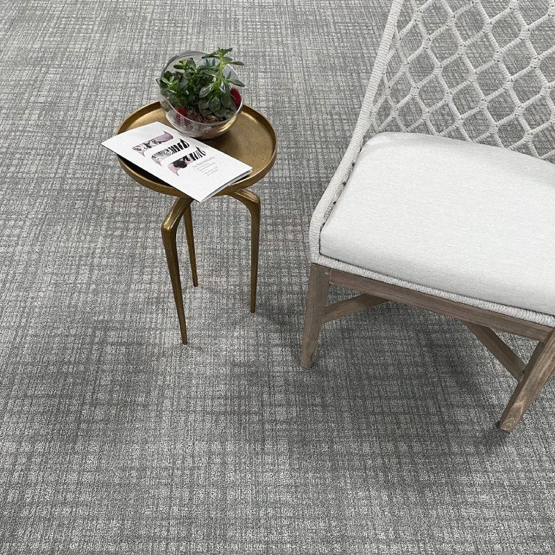 A white TREASURE MAP broadloom chair and table in a room with gray carpet.