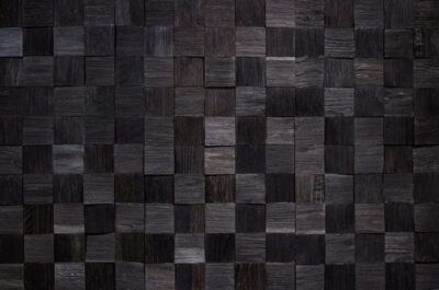 A black tile wall with squares of wood