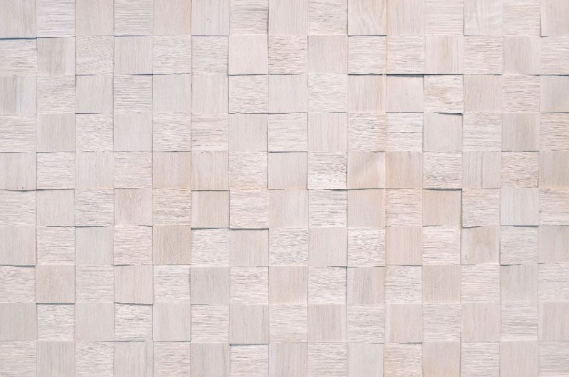 A white wall with many squares of wood