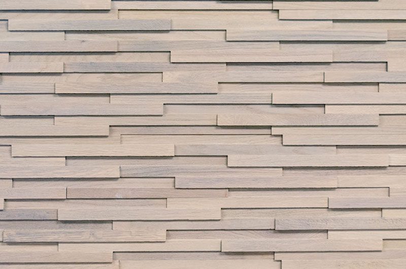 A wall with many different sized strips of wood.