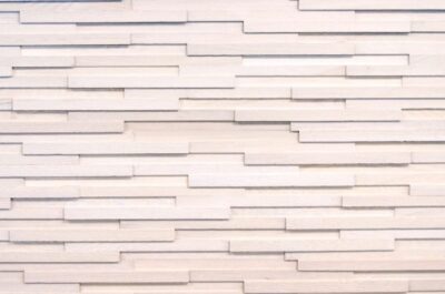 A white wall with many strips of wood.
