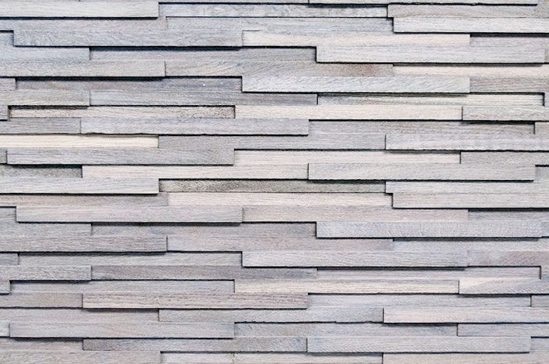 A close up of the wall with many different types of wood.
