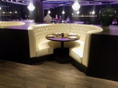 A restaurant with a white booth and an Espresso table.