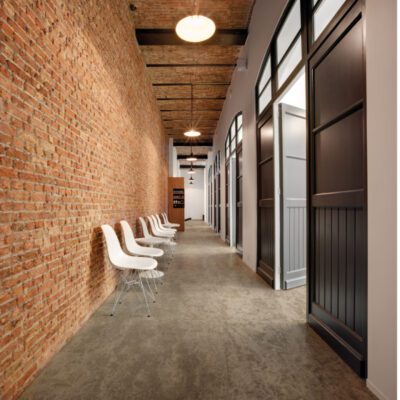 A hallway with Gobi chairs and brick walls.