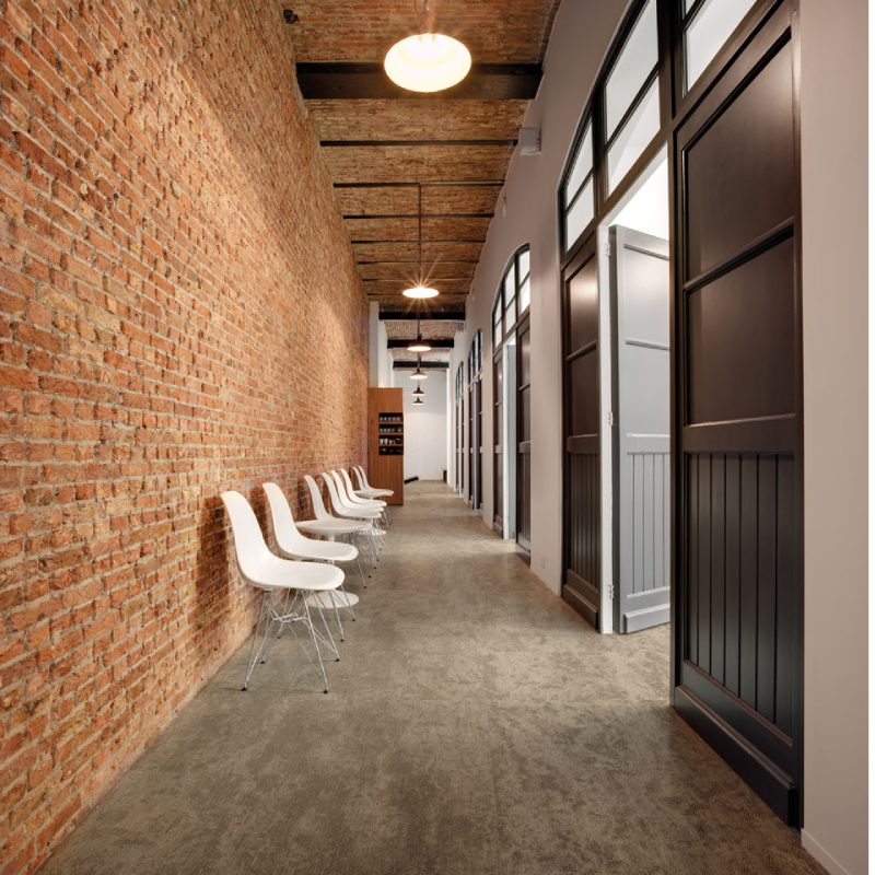 A hallway with Gobi chairs and brick walls.