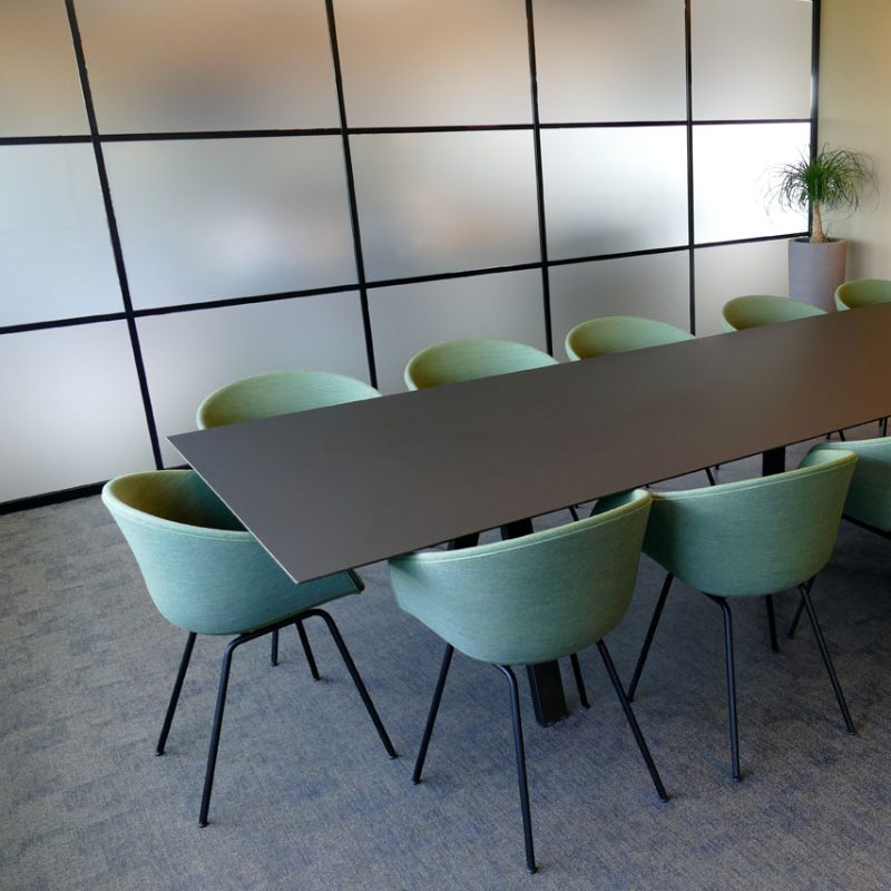 A conference room with green chairs and a Solaris table.