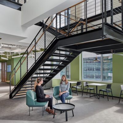 Two women sitting in chairs in an office with Stardust stairs.